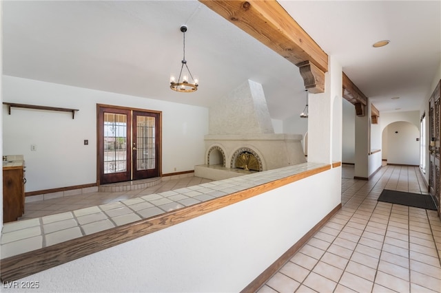 6861 E Washington Ave, Las Vegas, NV 89110 - corridor featuring light tile patterned floors, arched walkways, a chandelier, french doors, and baseboards