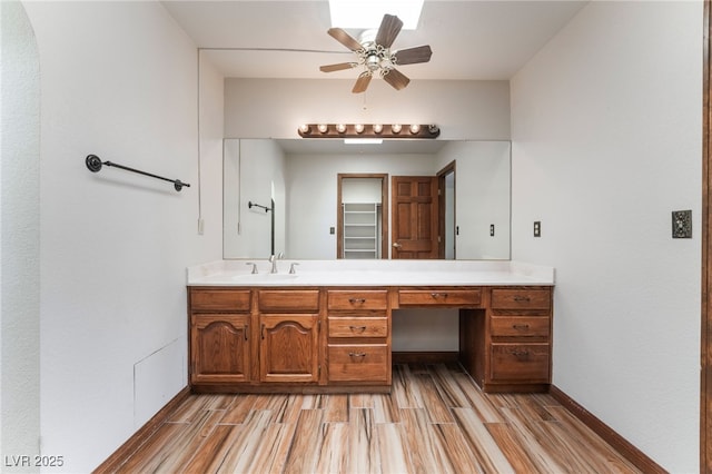 6861 E Washington Ave, Las Vegas, NV 89110 - bathroom with wood finished floors, vanity, baseboards, and ceiling fan