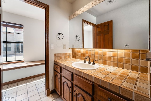 6861 E Washington Ave, Las Vegas, NV 89110 - bathroom with backsplash, tile patterned flooring, vanity, and baseboards