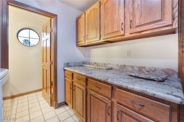 6861 E Washington Ave, Las Vegas, NV 89110 - kitchen with baseboards, light tile patterned flooring, and brown cabinets
