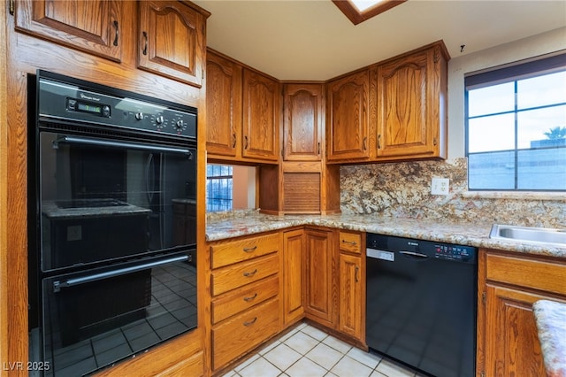 6861 E Washington Ave, Las Vegas, NV 89110 - kitchen with black appliances, brown cabinetry, healthy amount of natural light, and light tile patterned flooring