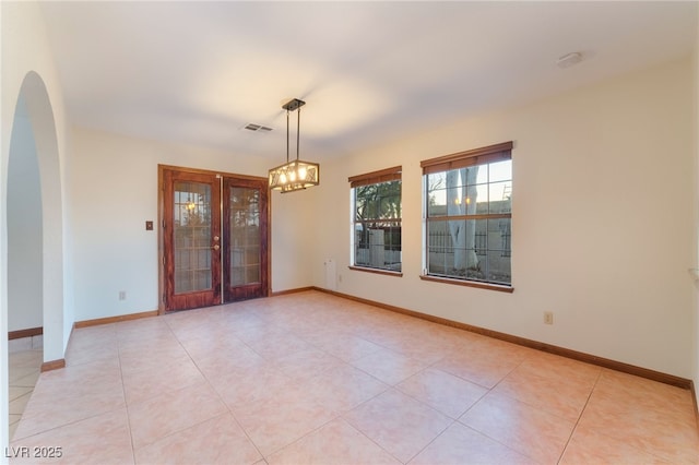 6861 E Washington Ave, Las Vegas, NV 89110 - empty room featuring arched walkways, french doors, a chandelier, and light tile patterned floors