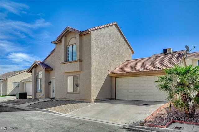 mediterranean / spanish-style house featuring a tiled roof, an attached garage, concrete driveway, and stucco siding