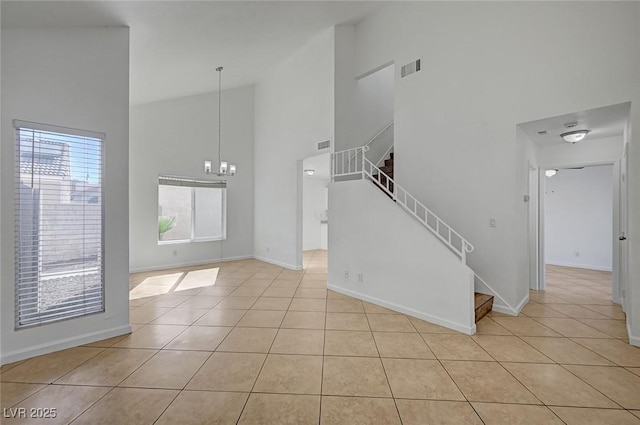 unfurnished living room featuring light tile patterned floors, baseboards, an inviting chandelier, stairway, and high vaulted ceiling