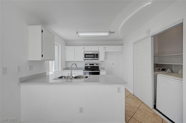 kitchen with a peninsula, light countertops, white cabinetry, appliances with stainless steel finishes, and a sink