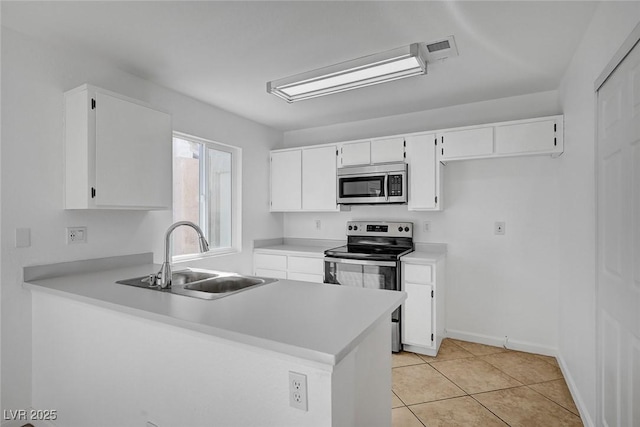 kitchen featuring a peninsula, light countertops, white cabinetry, stainless steel appliances, and a sink