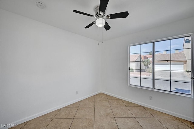 unfurnished room with ceiling fan, light tile patterned flooring, and baseboards