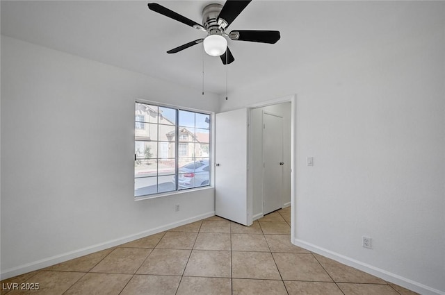 unfurnished bedroom with light tile patterned floors, baseboards, and a ceiling fan