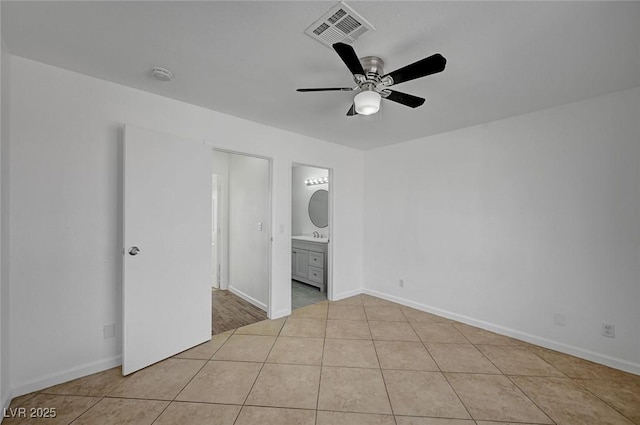 unfurnished bedroom featuring light tile patterned floors, visible vents, baseboards, and connected bathroom