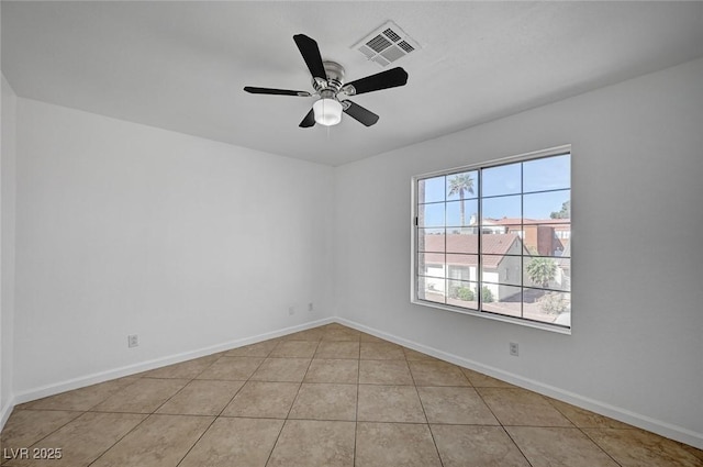 empty room with light tile patterned floors, baseboards, a ceiling fan, and visible vents
