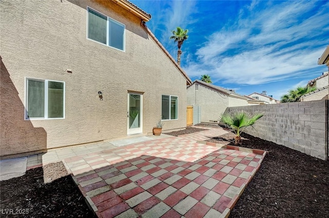 back of property with a patio, a fenced backyard, and stucco siding