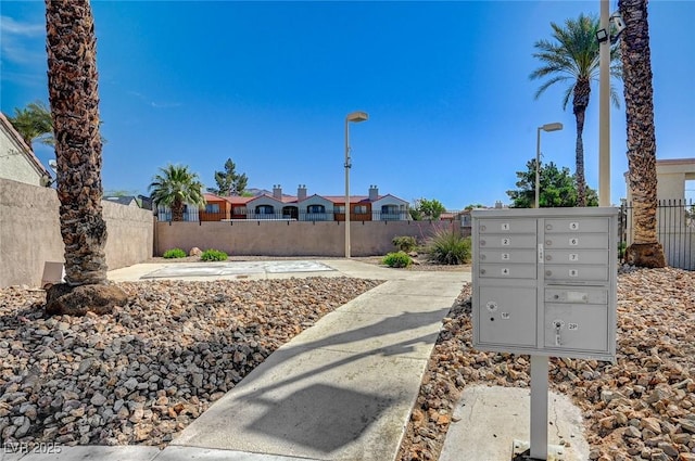 view of community featuring mail area and fence