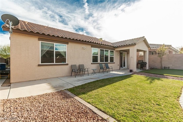 rear view of property with fence, stucco siding, and a tile roof
