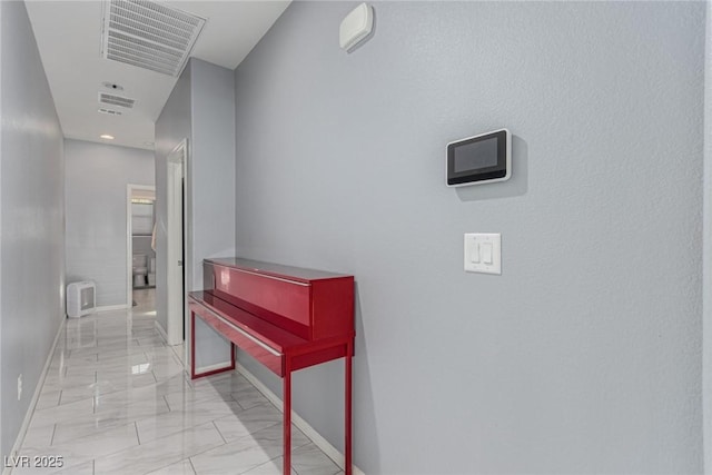 corridor featuring visible vents, marble finish floor, and baseboards