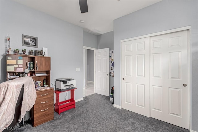office area featuring ceiling fan, dark colored carpet, and baseboards