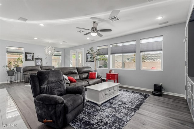 living area featuring baseboards, visible vents, and wood finished floors