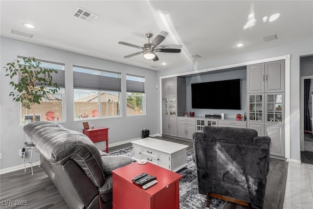 living area with visible vents, ceiling fan, baseboards, recessed lighting, and wood finished floors