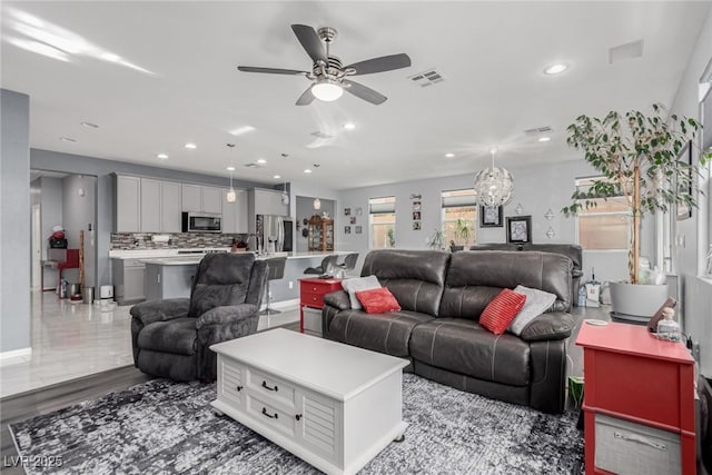 living room featuring recessed lighting, a ceiling fan, visible vents, and baseboards