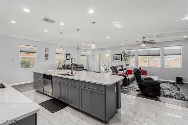 7386 Campbell Ranch Ave, Las Vegas, NV 89179 - kitchen featuring stainless steel dishwasher, a sink, open floor plan, gray cabinetry, and plenty of natural light