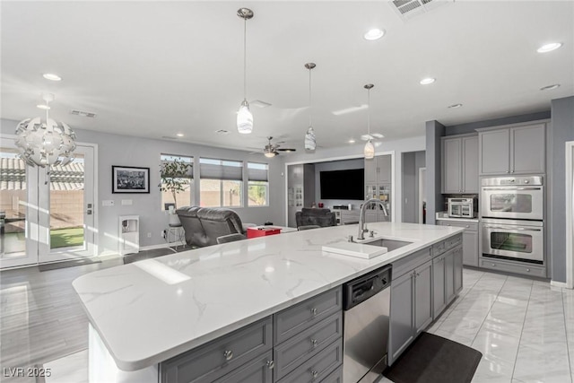 kitchen featuring gray cabinetry, stainless steel appliances, and a sink