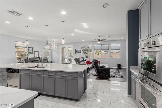 7386 Campbell Ranch Ave, Las Vegas, NV 89179 - kitchen featuring gray cabinets, appliances with stainless steel finishes, open floor plan, light countertops, and recessed lighting