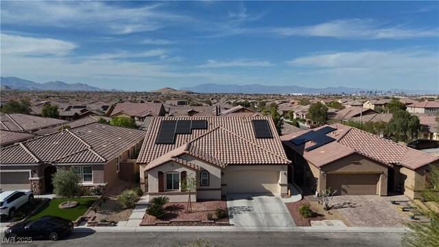 view of front of home with a tile roof, a residential view, stucco siding, driveway, and an attached garage
