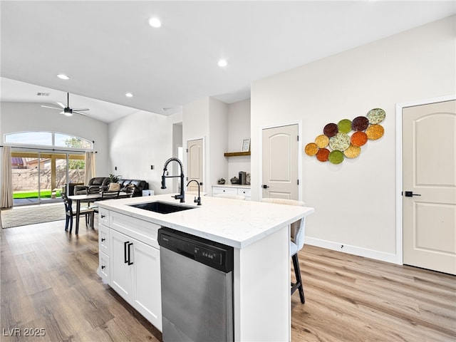 kitchen with a kitchen island with sink, white cabinets, a sink, light wood finished floors, and dishwasher