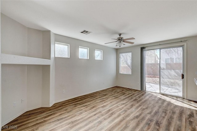 empty room featuring ceiling fan, wood finished floors, and baseboards