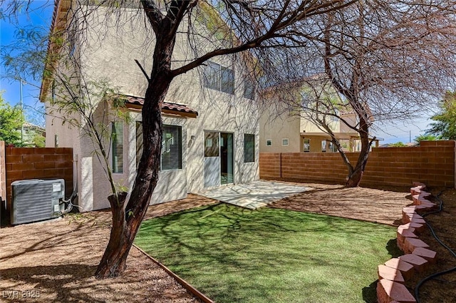 rear view of house with stucco siding, central air condition unit, and a patio area