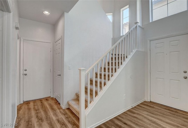 entrance foyer featuring wood finished floors, stairway, recessed lighting, and baseboards