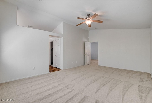 carpeted spare room with lofted ceiling, a ceiling fan, and baseboards