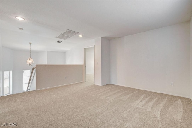 empty room featuring light colored carpet, recessed lighting, and baseboards