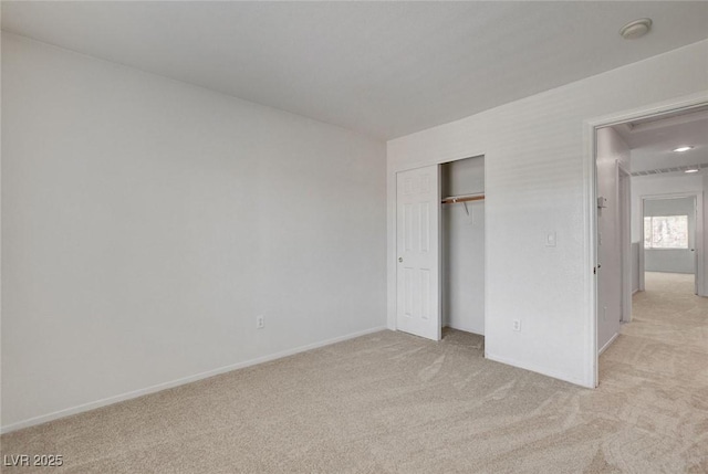 unfurnished bedroom with light colored carpet, baseboards, and a closet