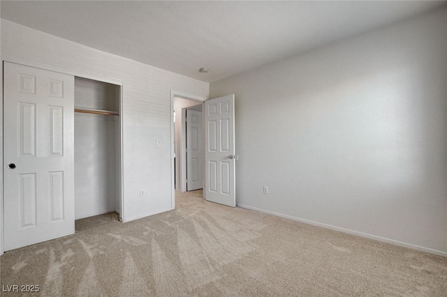 unfurnished bedroom featuring carpet, a closet, and baseboards