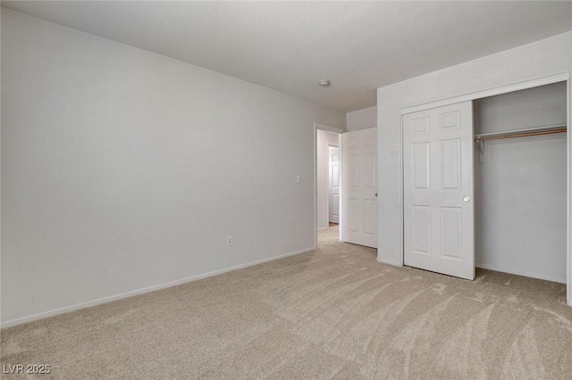 unfurnished bedroom with light colored carpet, baseboards, and a closet