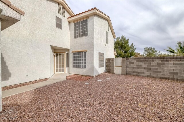 8005 Exploration Ave, Las Vegas, NV 89131 - rear view of property featuring a gate, a tiled roof, stucco siding, and fence