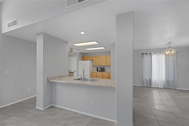 8005 Exploration Ave, Las Vegas, NV 89131 - kitchen with light brown cabinetry, light countertops, visible vents, and freestanding refrigerator