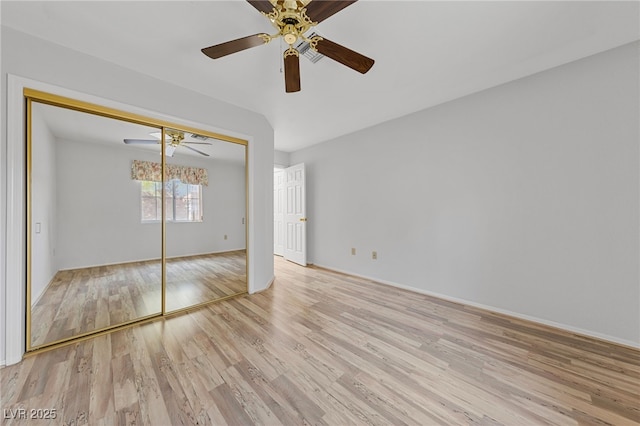 unfurnished bedroom featuring a closet, a ceiling fan, baseboards, and wood finished floors
