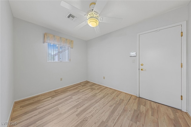 empty room with ceiling fan, visible vents, and wood finished floors