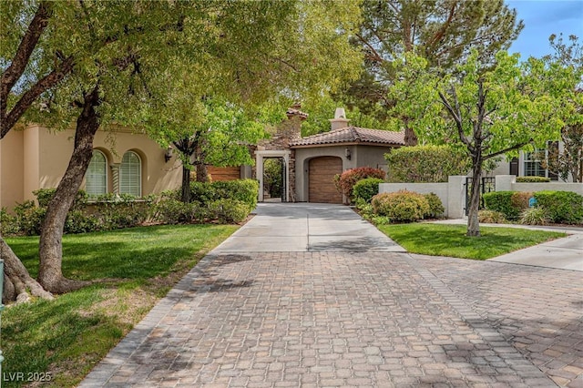 11814 Canons Brook Dr, Las Vegas, NV 89141 - mediterranean / spanish house with stucco siding, decorative driveway, an attached garage, a front yard, and a tiled roof