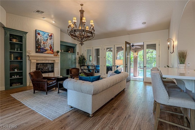 11814 Canons Brook Dr, Las Vegas, NV 89141 - living area with an inviting chandelier, french doors, visible vents, a tile fireplace, and wood finished floors
