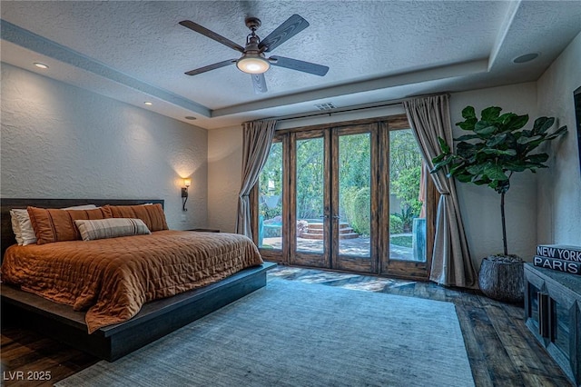 11814 Canons Brook Dr, Las Vegas, NV 89141 - bedroom with a textured wall, a textured ceiling, a tray ceiling, access to exterior, and wood finished floors