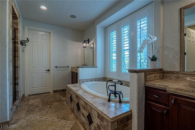 11814 Canons Brook Dr, Las Vegas, NV 89141 - bathroom featuring a tile shower, a bath, a textured ceiling, vanity, and a textured wall