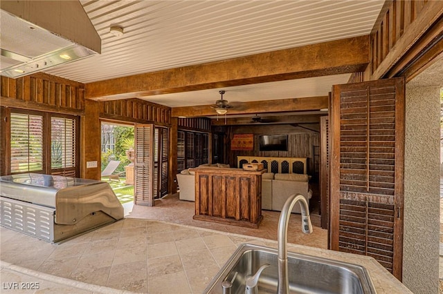 11814 Canons Brook Dr, Las Vegas, NV 89141 - kitchen featuring a sink, wood walls, a ceiling fan, and beam ceiling