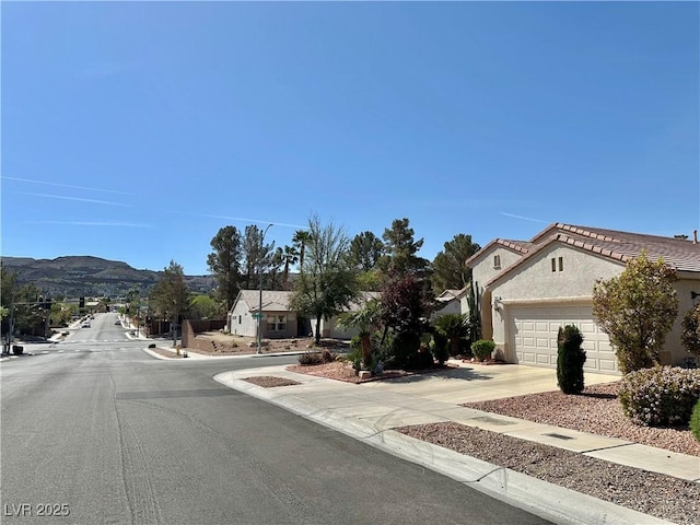 view of road featuring curbs, sidewalks, and a mountain view