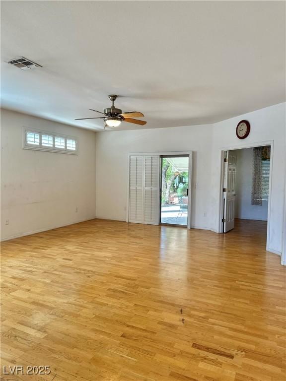 unfurnished room with visible vents, a ceiling fan, and light wood-style flooring