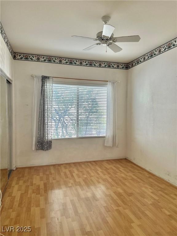 spare room featuring a ceiling fan and light wood-style floors