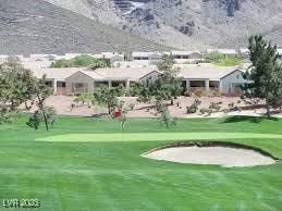 view of community featuring a lawn and view of golf course