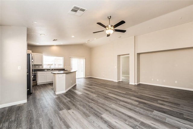3434 Denali Preserve St, Las Vegas, NV 89122 - unfurnished living room featuring ceiling fan, dark wood finished floors, visible vents, lofted ceiling, and baseboards