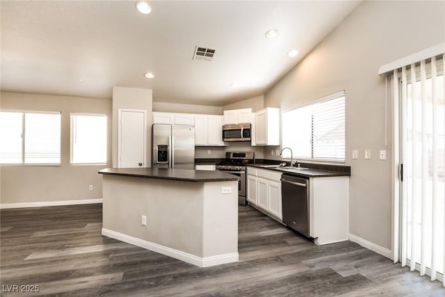 3434 Denali Preserve St, Las Vegas, NV 89122 - kitchen with visible vents, a sink, appliances with stainless steel finishes, dark countertops, and a kitchen island